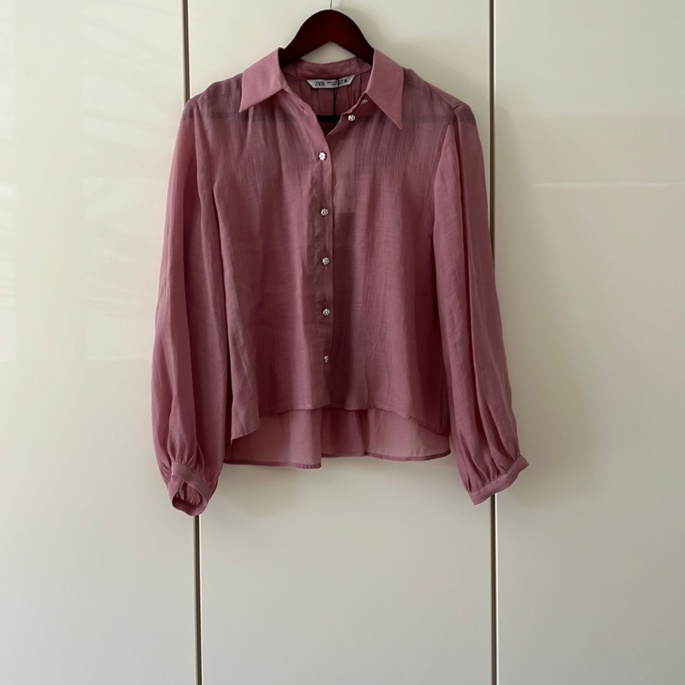 Sheer blouse with rhinestone buttons.